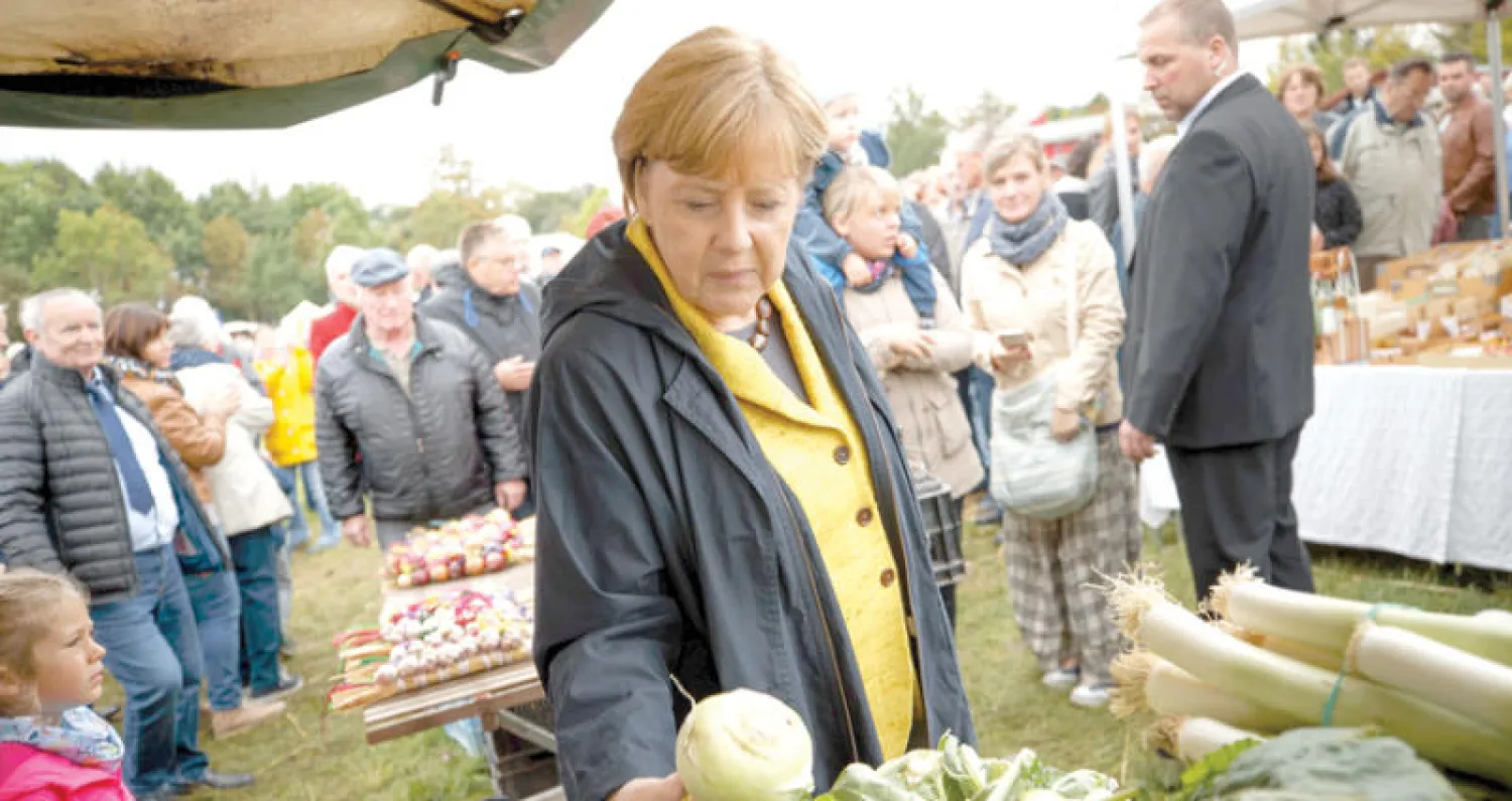 المستشارة الألمانية أنجيلا ميركل خلال زيارتها مزرعة في ميكليبورغ - فوربومره شرق ألمانيا أمس (إ.ب.أ)