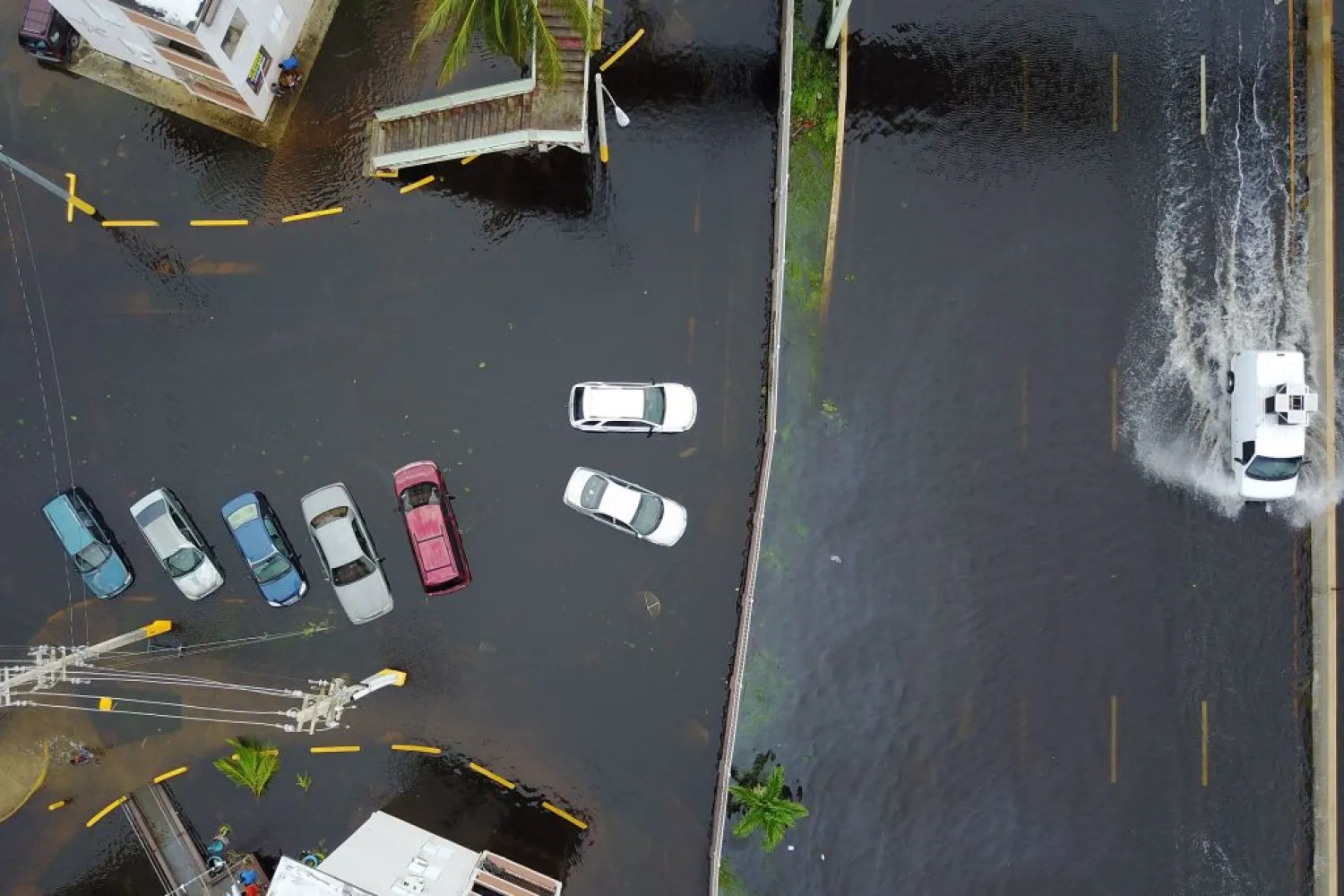 Cars drive through a flooded road in the aftermath of Hurricane Maria in San Juan, Puerto Rico, Thursday, September 21, 2017. RICARDO ARDUENGO/AFP