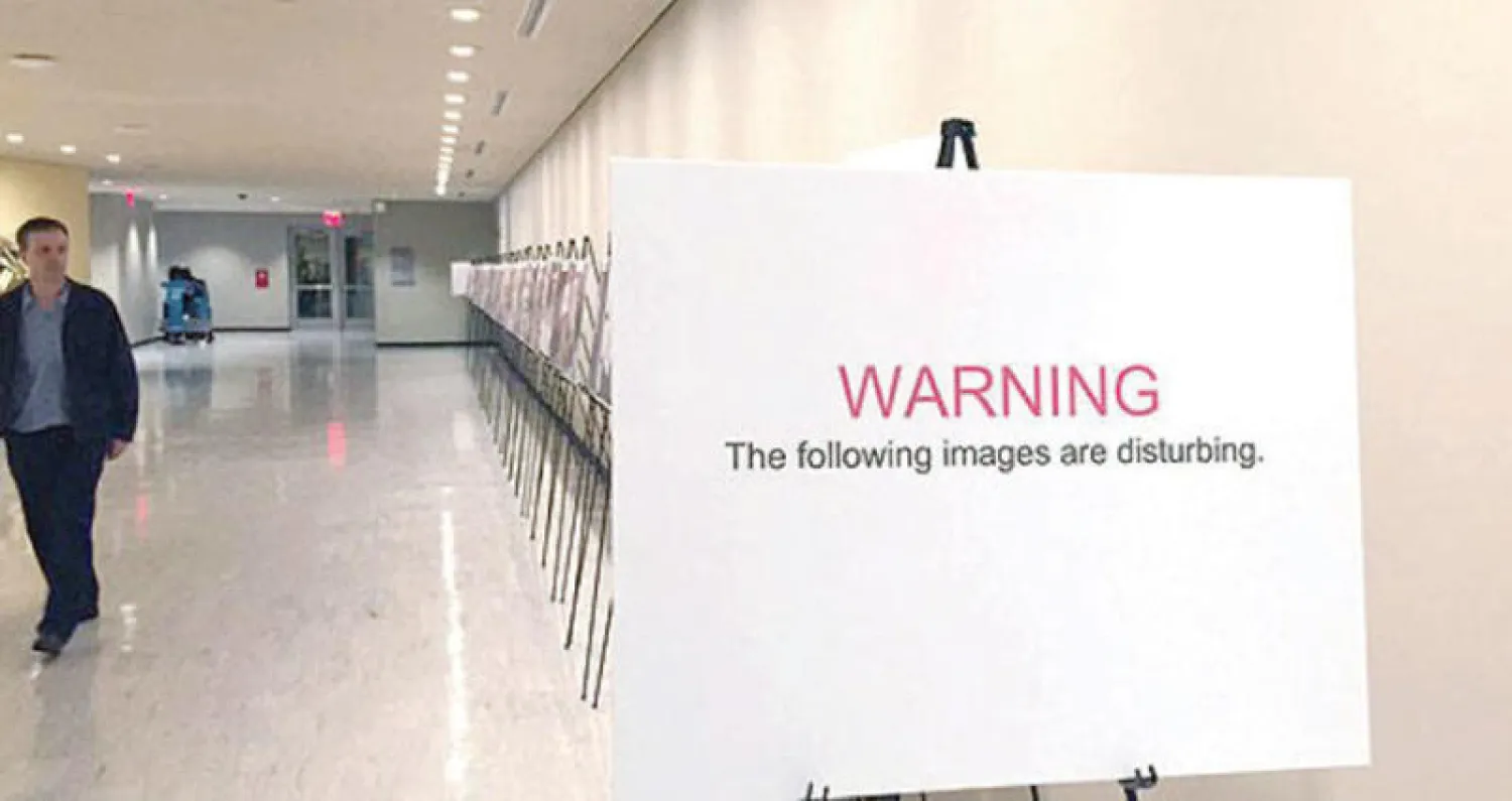 لافتة في مدخل معرض «قيصر» الذي يقام في الأمم المتحدة تحذر الجمهور من هول الصور التي سيرونها (أ.ب)
