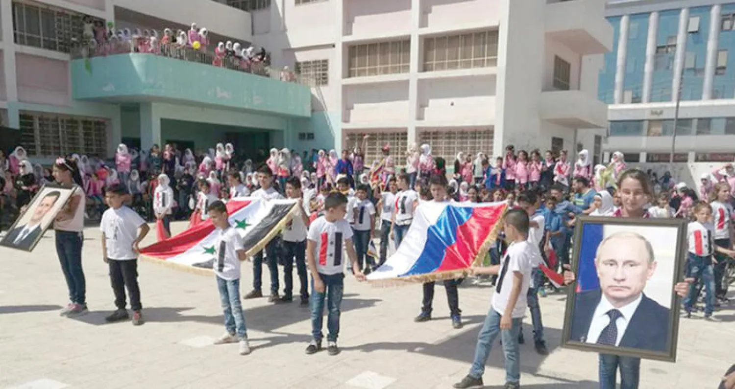 صورة الرئيس الروسي فلاديمير بوتين وعلم بلاده في افتتاح مدرسة رسمية في درعا (أخبار درعا)