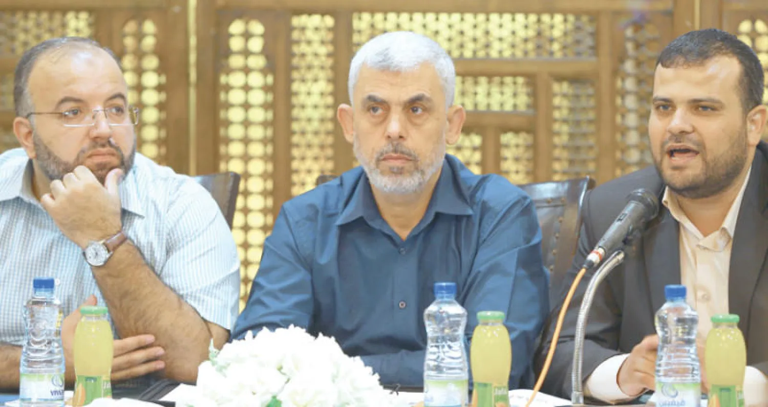 السنوار (وسط) ينصت لأحد المتحدثين في اجتماع لشبيبة {حماس} عقد في غزة أمس (أ.ف.ب)