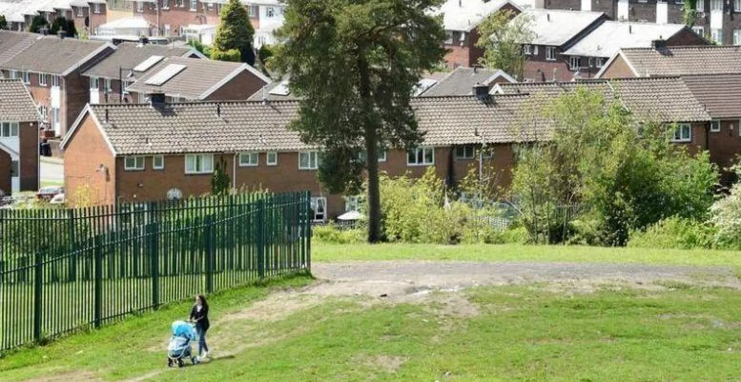 امرأة تسير أمام مجمع سكني في ويلز (رويترز)