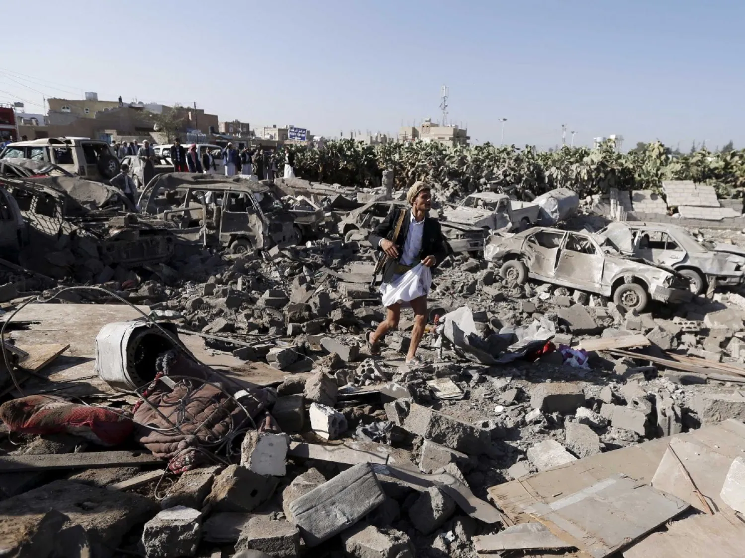 An armed man walks on the rubble of houses destroyed by an air strike near Sana'a Airport March 26, 2015. Reuters