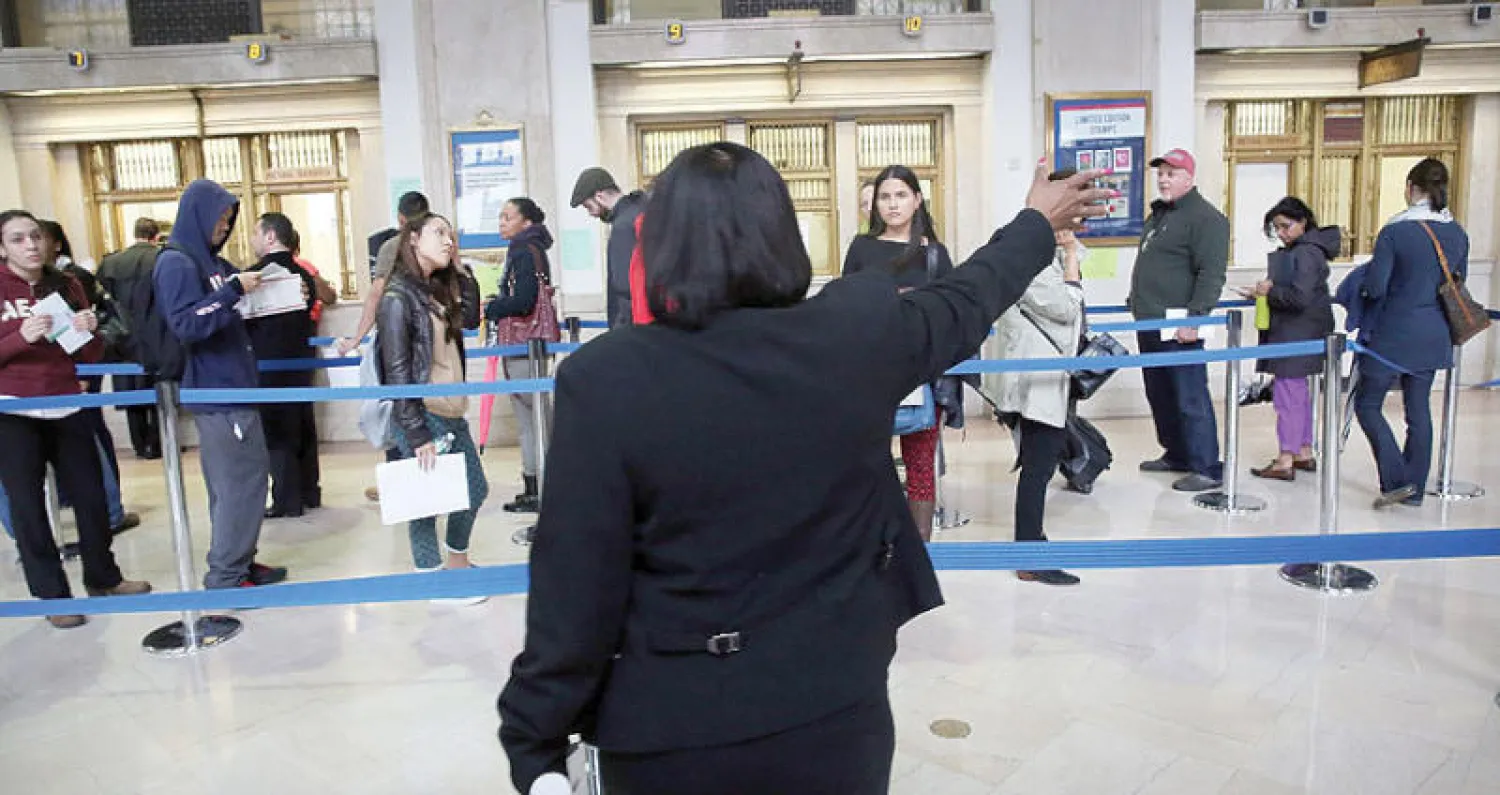 أميركيون يصطفون في مكتب بريد بمنهاتن لإرسال الإقرارات الضريبية قبل الموعد النهائي (غيتي)