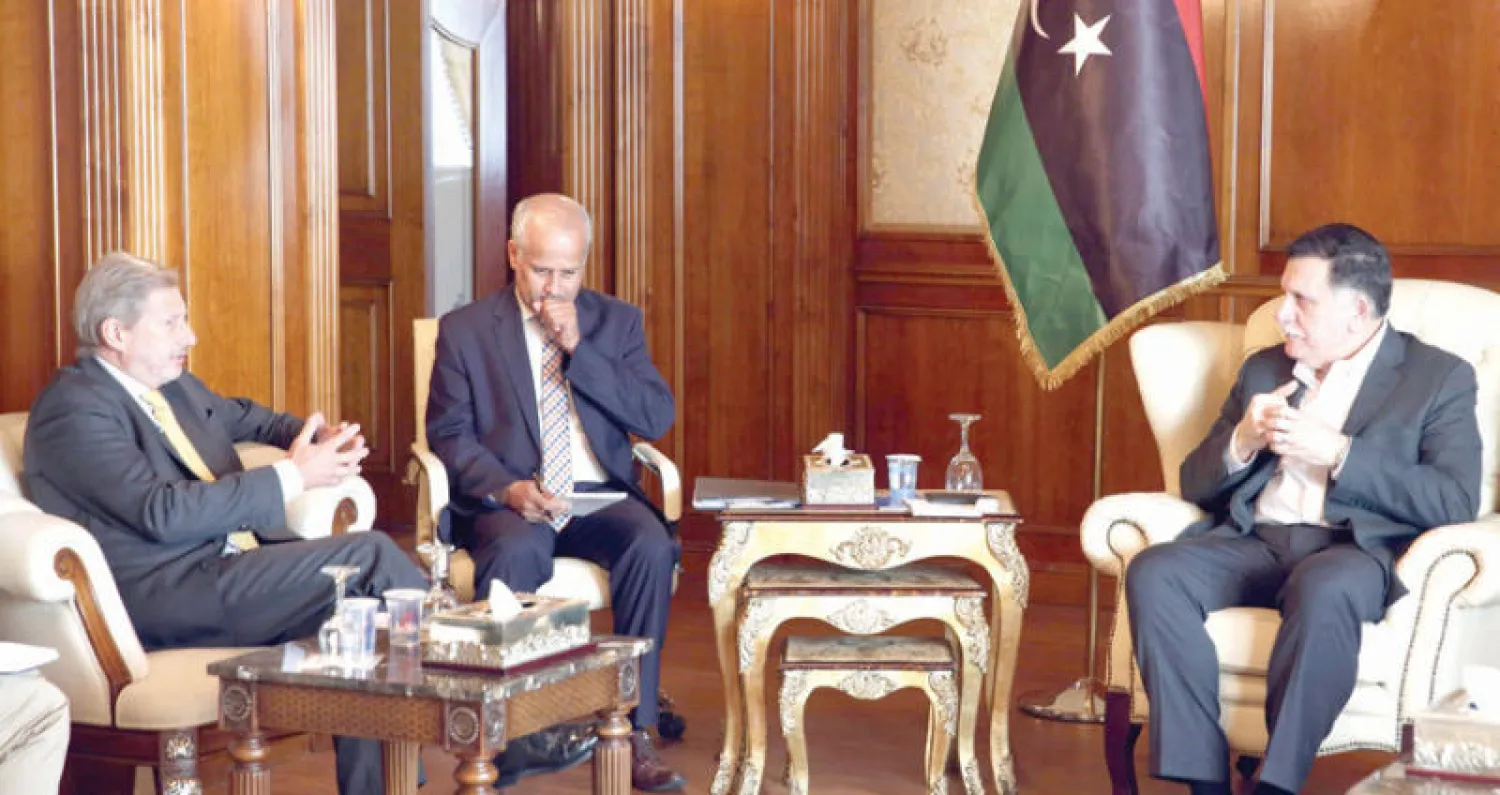 رئيس حكومة الوفاق فائز السراج (يمين) مجتمعاً مع المفوض الاوروبي لشؤون الجوار يوهانس هان في طرابلس أمس (أ.ف.ب)