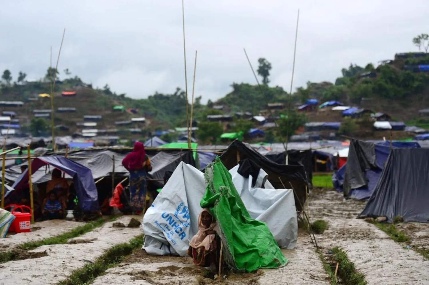 A Rohingya refugee woman sits next to a newly built makeshift shelter in a camp in the Bangladeshi locality of Ukhia on September 9, 2017. (AFP)