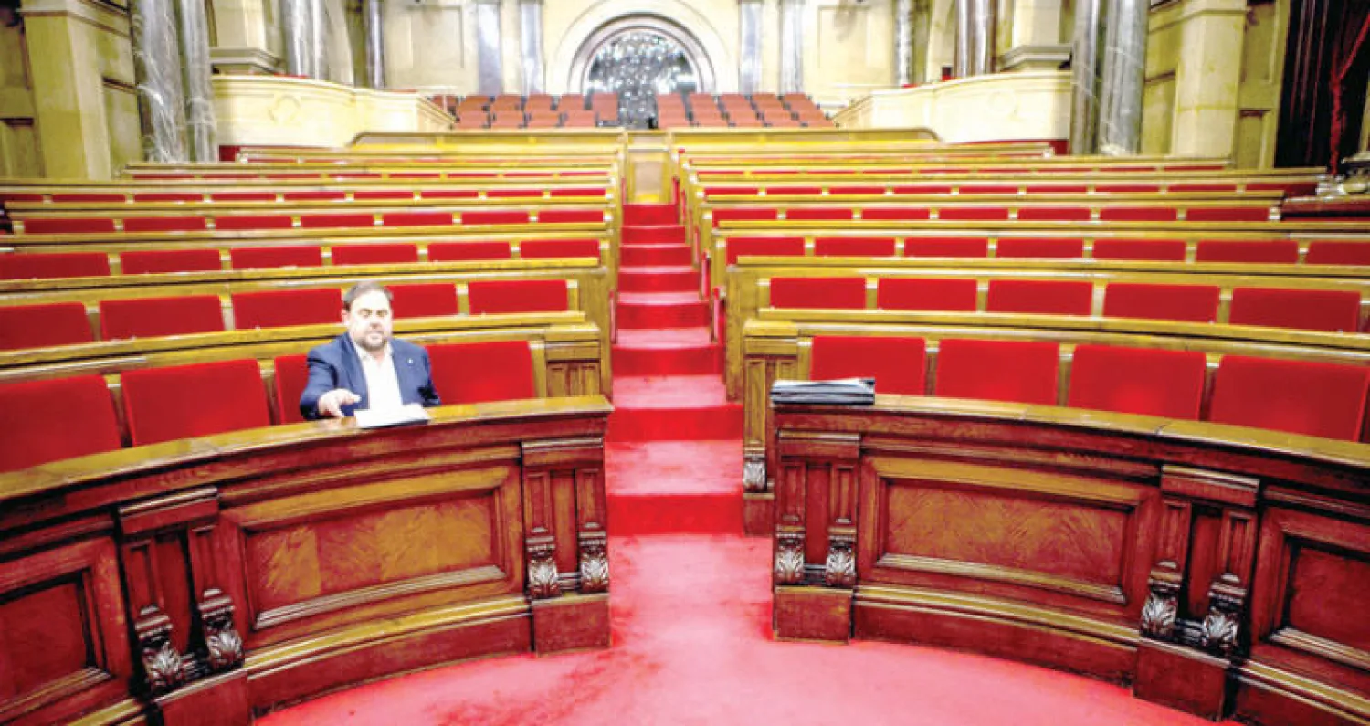 نائب رئيس كاتالونيا أوريول يأخذ مكانه قبل بدء جلسة سابقة داخل برلمان الإقليم في برشلونة (إ.ب.أ)