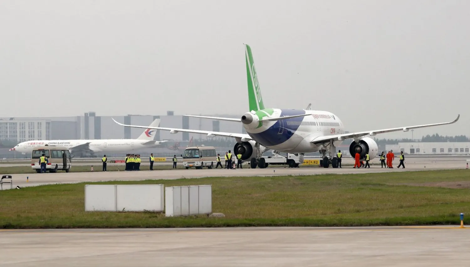 A China Eastern Airlines plane (L) taxis near a Chinese C919 passenger jet before its scheduled first flight at Pudong International Airport in Shanghai on May 5, 2017. / AFP PHOTO