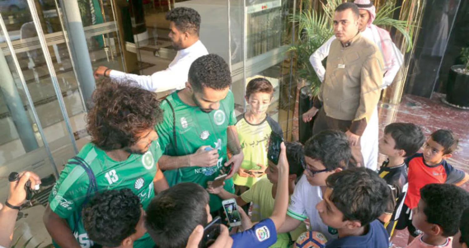 مجموعة من الأطفال يتحلقون حول الثنائي البريك والشهراني أمام مدخل الفندق في جدة أمس