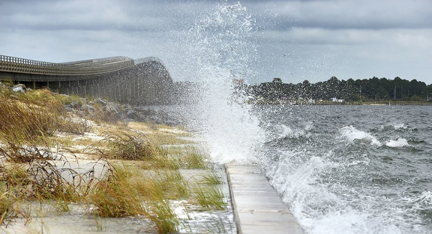 The wind from Hurricane Nate pushes waves from the Santa Rosa Sound on October 7, across the Navarre Beach causeway in Navarre Beach, Florida. (AP)