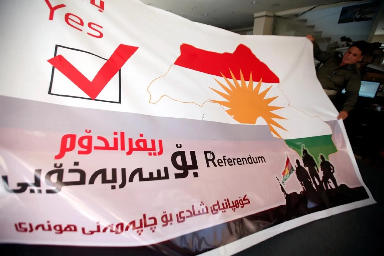 A man holds a printed banner of Kurdistan region referendum in Irbil, Iraq August 26, 2017. (Reuters)