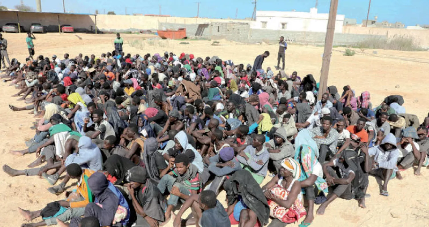 مهاجرون تم تجميعهم أمس داخل مركز لإيواء اللاجئين في مدينة زوارة (رويترز)