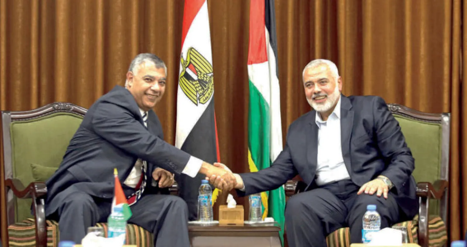 إسماعيل هنية يصافح رئيس المخابرات المصرية خالد فوزي في غزة خلال زيارته الأسبوع الماضي (رويترز)