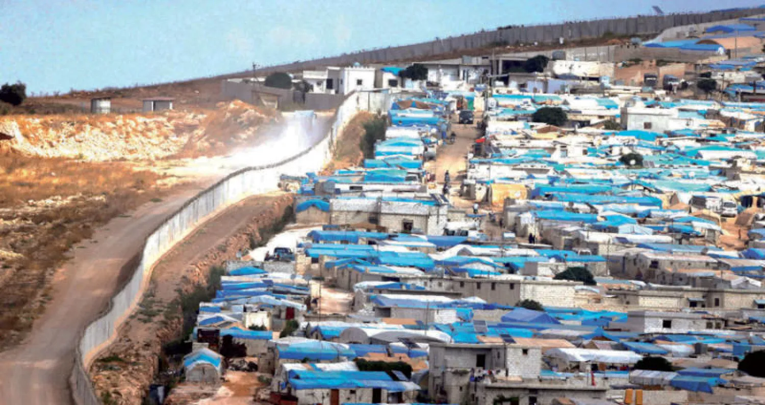 مخيم أطمة للنازحين السوريين وراء جدار عازل على حدود تركيا (رويترز)