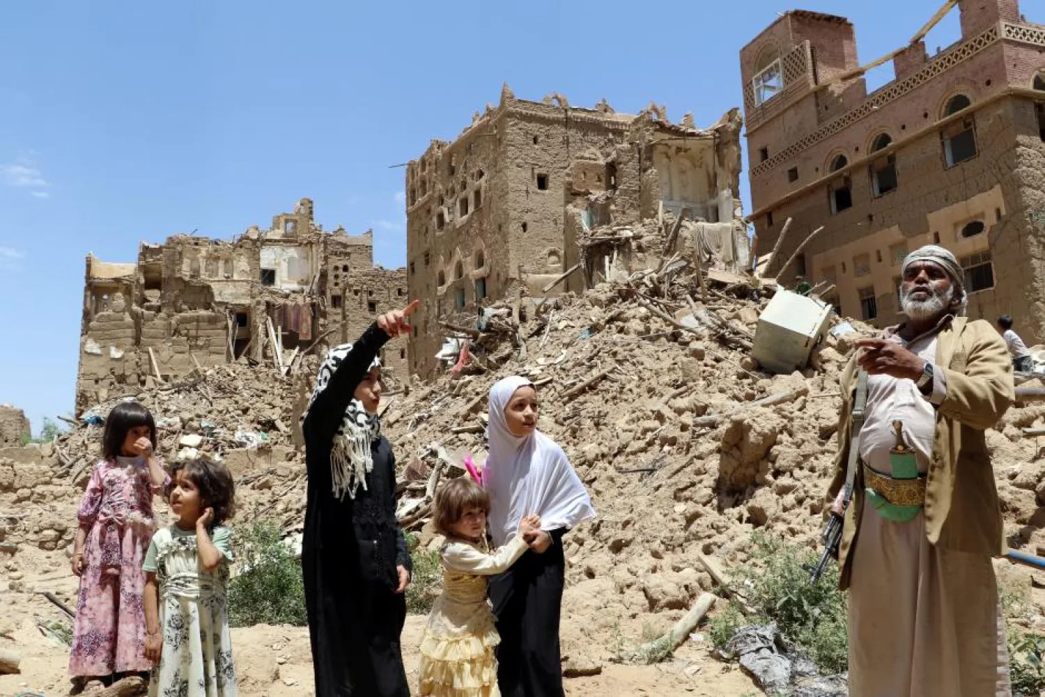 People stand past destroyed houses in an outskirt of the northwestern city of Saada, Yemen September 5, 2017. Reuters