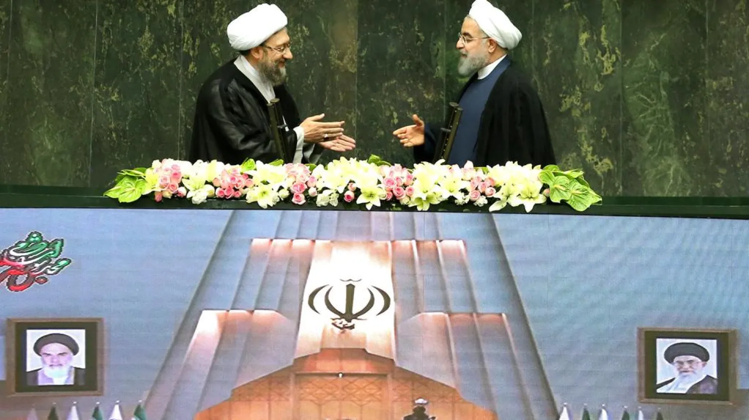  Iranian president Hassan Rouhani extends his hand to Iran's Judiciary chief Sadegh Larijani during a Tehran swearing-in ceremony for Rouhani's latest term, August 5, 2017. Nazanin Tabatabaee Yazdi/TIMA via REUTERS