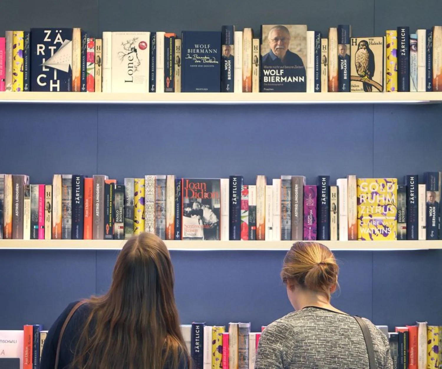 Women stand in front of shelves at the 2016 Frankfurt Book Fair. (AFP)