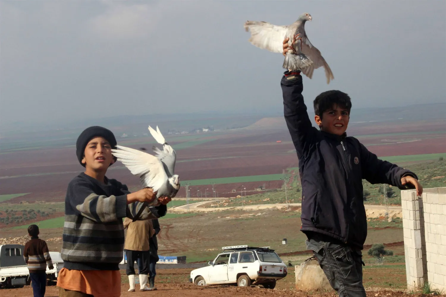 Children hold pigeons at the Atme refugee camp that emerged due to the Syrian conflict along the Turkish border in the northwestern Syrian province of Idlib. AFP PHOTO