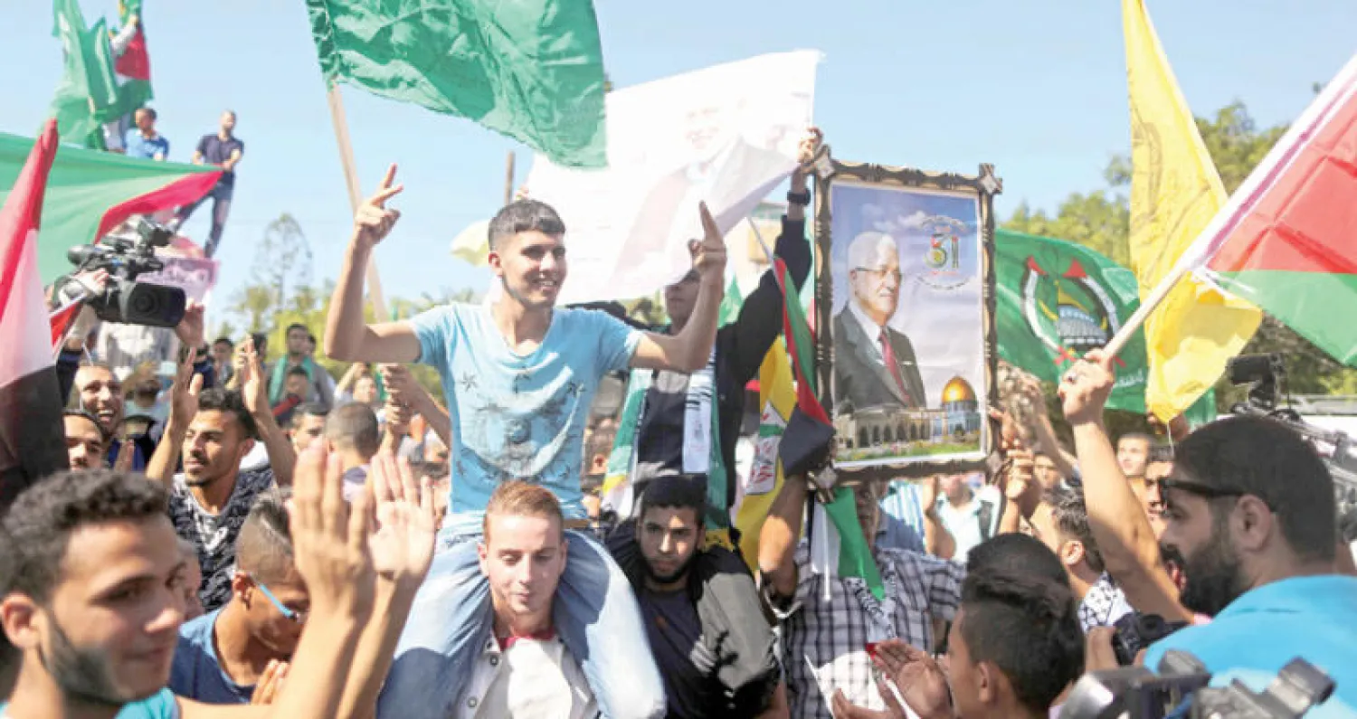 الفلسطينيون في غزة احتفلوا برفع الأعلام وصور الرئيس عباس وإسماعيل هنية ورقصوا في الشوارع (أ.ف.ب)