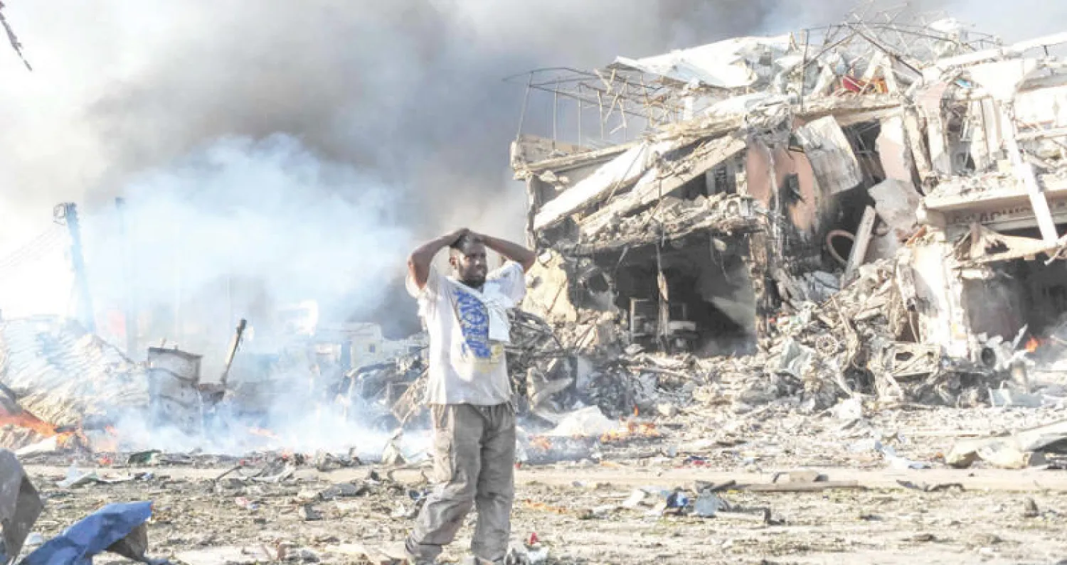 مواطن صومالي في حالة صدمة بالقرب من موقع تفجير السيارة المفخخة وسط العاصمة الصومالية مقديشو أمس (أ.ف.ب)