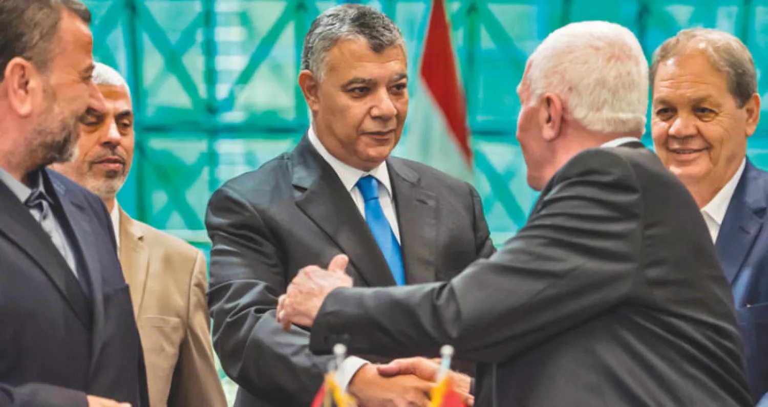 من اليسار: صالح العاروري ويحيى السنوار (حماس) ورئيس المخابرات المصرية خالد فوزي وعزام الأحمد (فتح) بعد توقيع اتفاق المصالحة (أ.ف.ب)