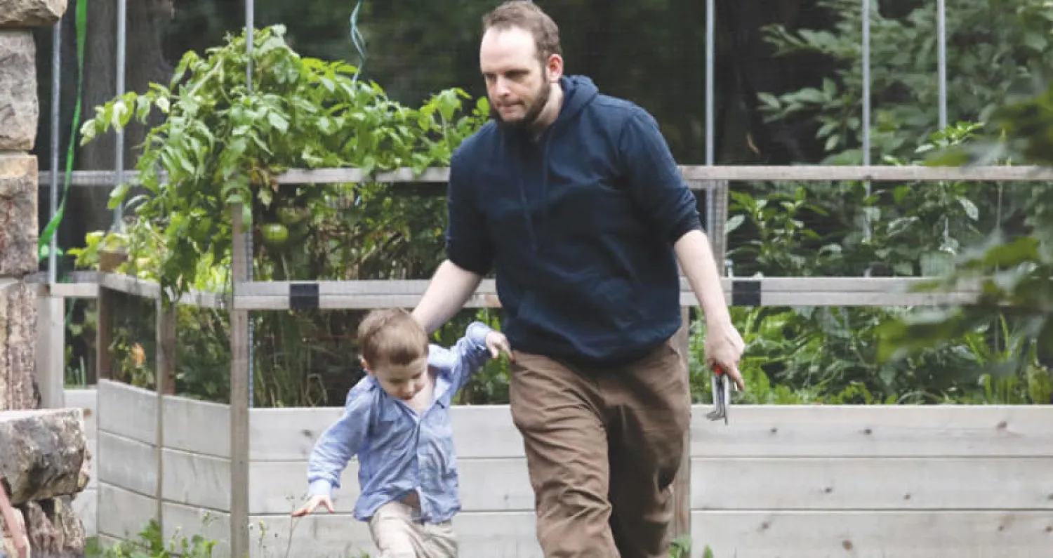 الرهينة الكندي جوشوا بويلي المفرج عنه منذ أيام مع أحد أطفاله خارج منزل العائلة في سميث فالز باونتاريو (أ.ف.ب)