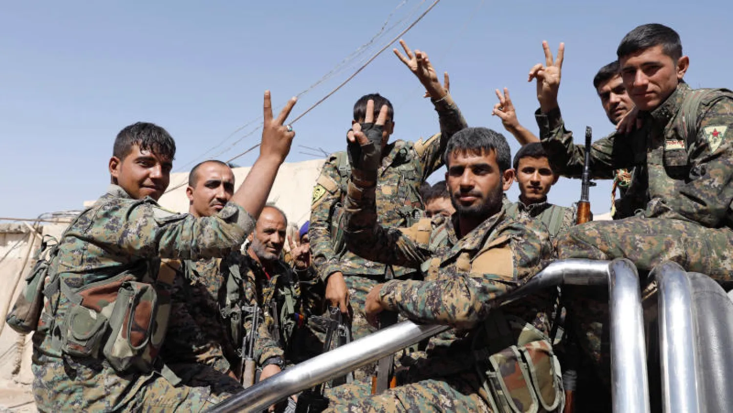 مقاتلون من قوات سوريا الديمقراطية على شاحنة في مدينة الرقة السورية (رويترز) 