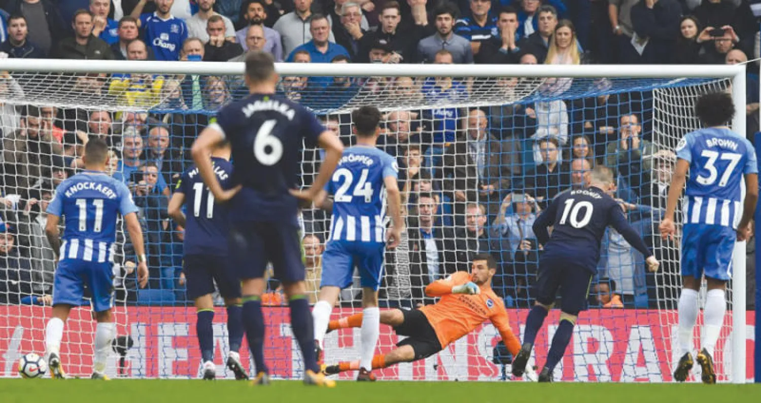 روني نجم إيفرتون (رقم 10 يمين) يسدد ركلة الجزاء في مرمى برايتون (أ.ف.ب)