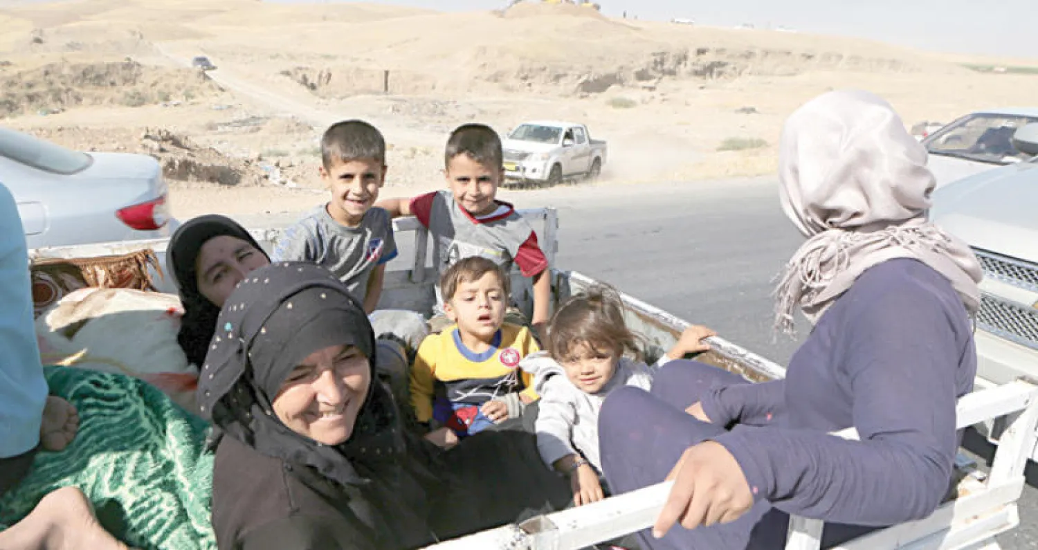 مواطنون يعودون إلى كركوك أمس بعد يوم من فرارهم منها إثر انسحاب قوات «البيشمركة» ودخول قوات الحكومة العراقية و«الحشد الشعبي» (أ.ب)