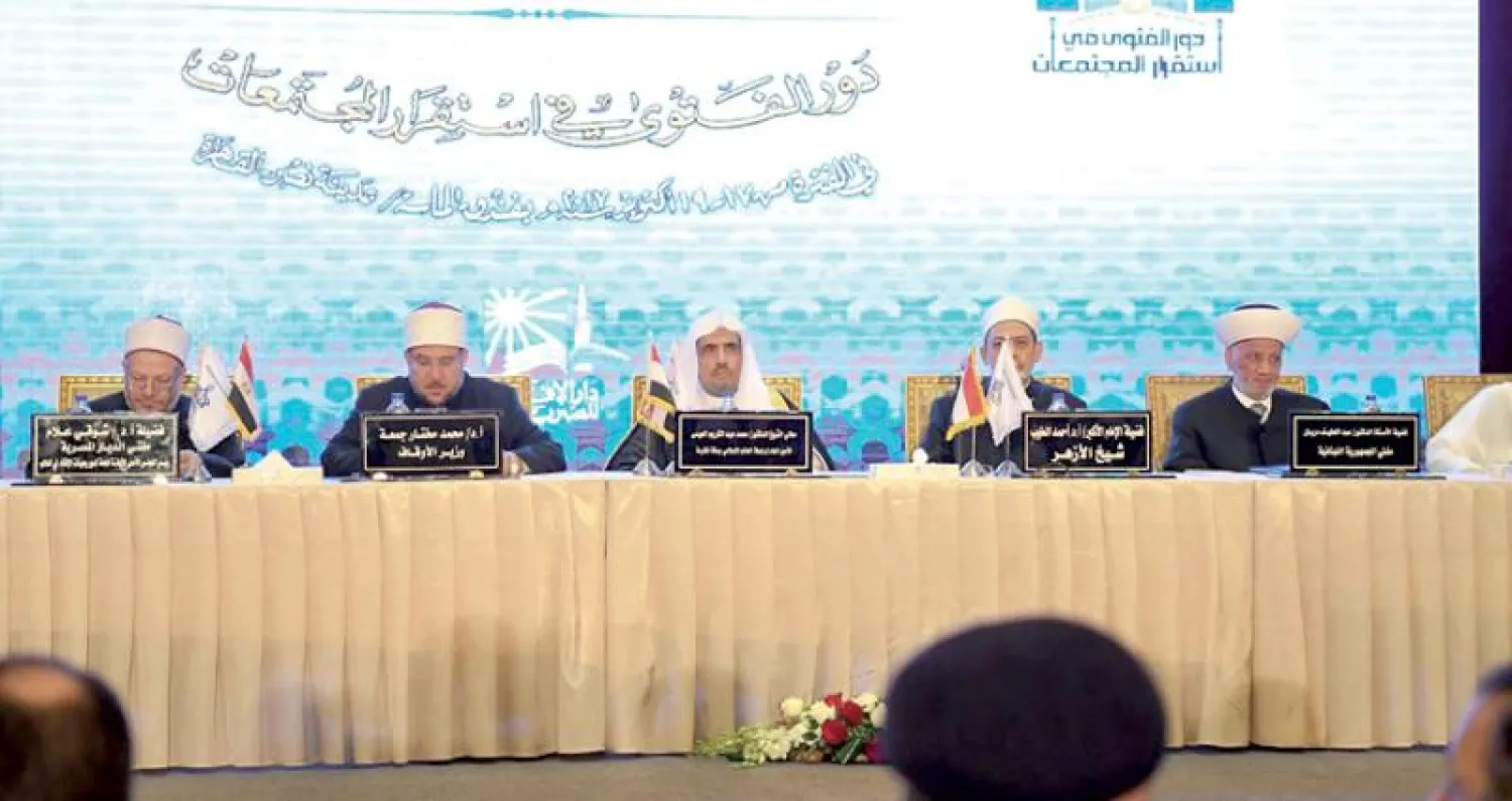 الدكتور العيسى على منصة حفل افتتاح المؤتمر يتوسط شيخ الأزهر ووزير الأوقاف المصري («الشرق الأوسط»)