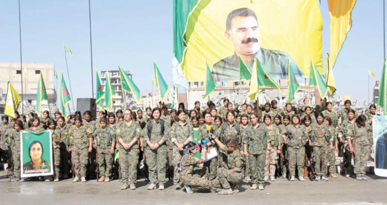 «قوات سوريا الديمقراطية» وسط الرقة أمام صورة عبد الله اوجلان زعيم «حزب العمال الكردستاني» ({الشرق الاوسط})