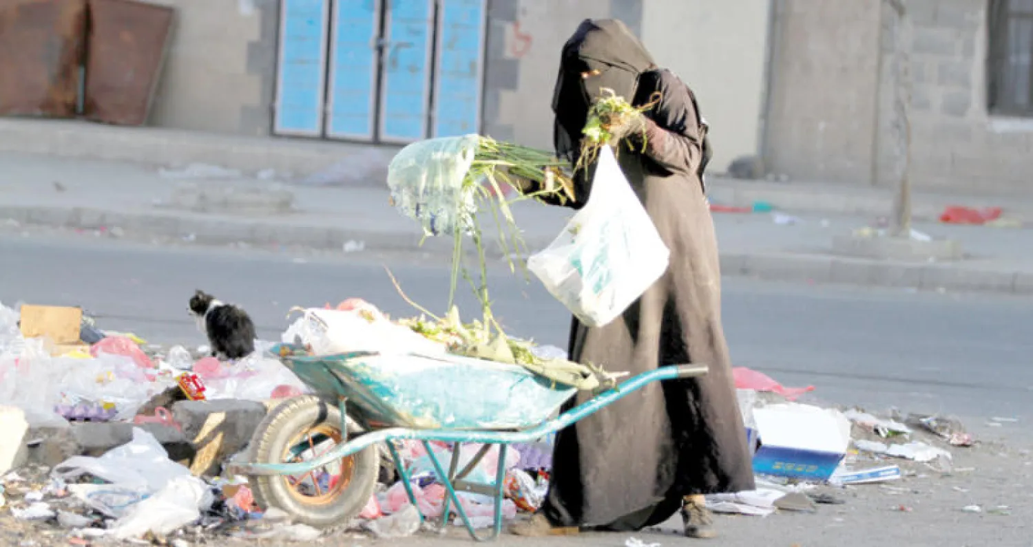 يمنية تبحث في القمامة عما يمكن استخدامه (رويترز)
