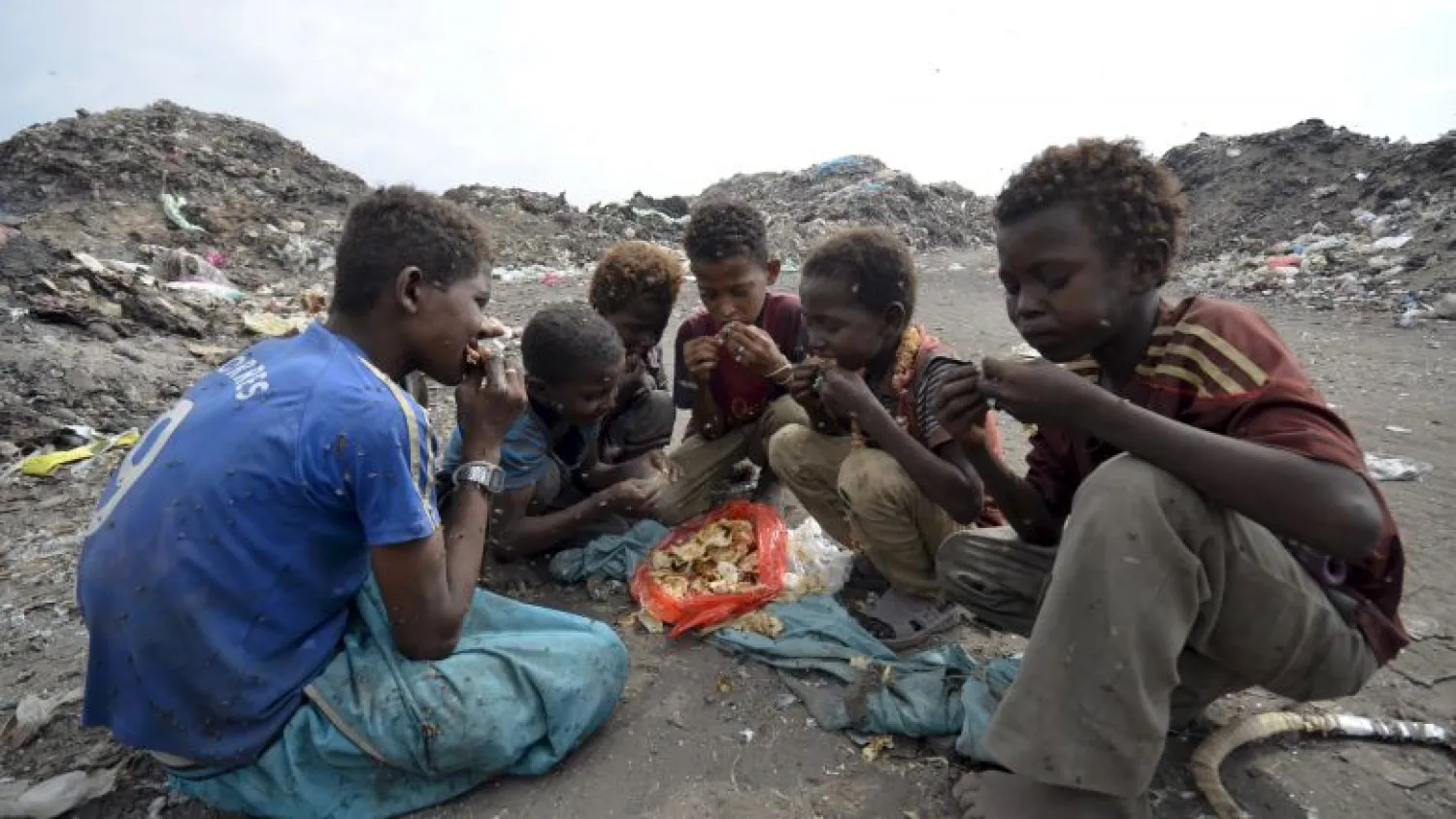 Boys eat at a rubbish dump where they are collecting recyclable waste outside Yemen's Red Sea port city of Houdieda in this January 20, 2016 file photo. REUTERS/Abduljabbar Zeyad/Files