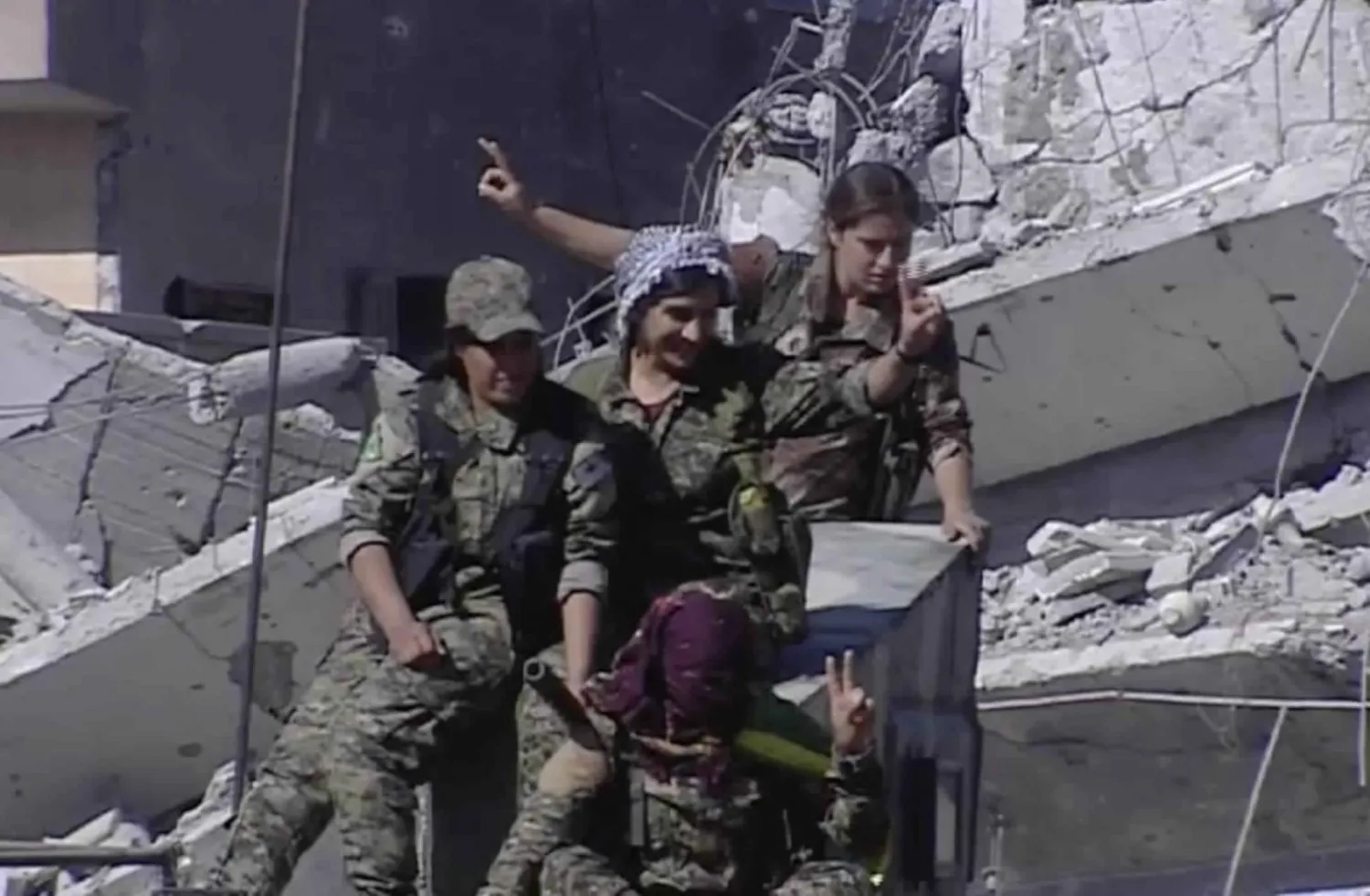 This frame grab from a video released on Thursday, Oct. 19, 2017 provided by Ronahi TV, shows members of the Women’s Protection Units, flashing victory signs as they celebrate the victory against ISIS, in Raqqa, Syria. (Ronahi TV, via AP) (Associated Press)