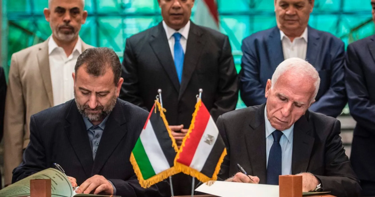  Fatah's Azam al-Ahmad (R) and Saleh al-Arouri of Hamas sign a reconciliation deal at the Egyptian intelligence services headquarters in Cairo on October 12, 2017. AFP
