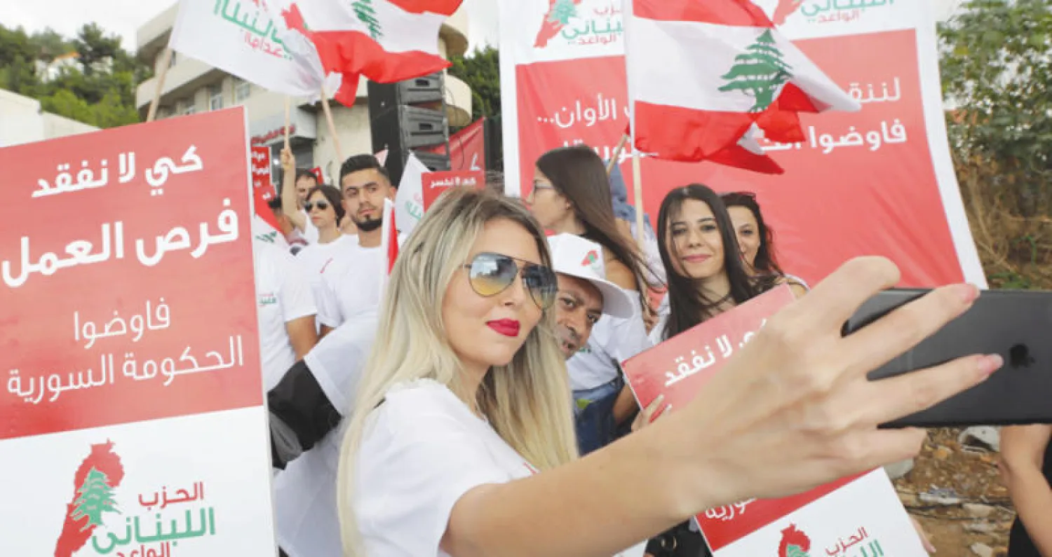 لبنانية تلتقط سيلفي أثناء مظاهرة في بلدة ذوق مصبح لإعادة النازحين السوريين منتصف الشهر الحالي (أ.ف.ب)