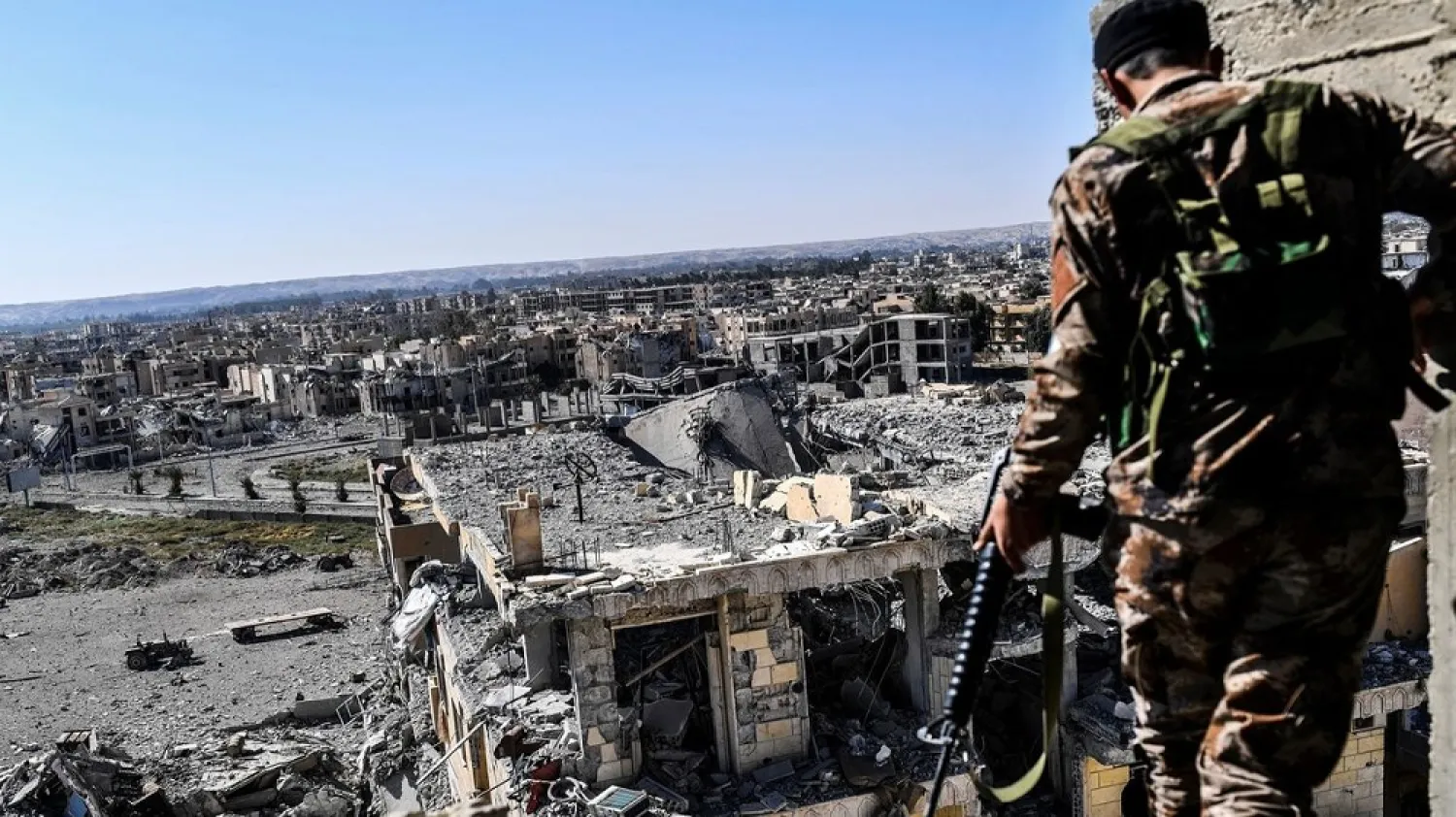 A member of the Syrian Democratic Forces walks on a building near Raqqa's stadium. (Getty Images)