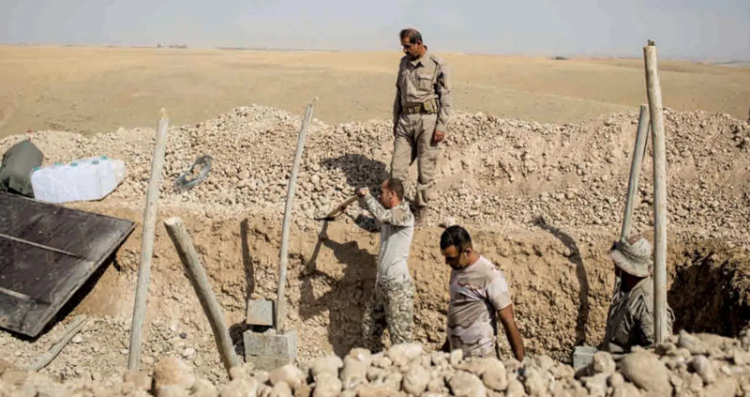 عناصر من البيشمركة يتخندقون على خط المواجهة شمال كركوك أمس (غيتي)