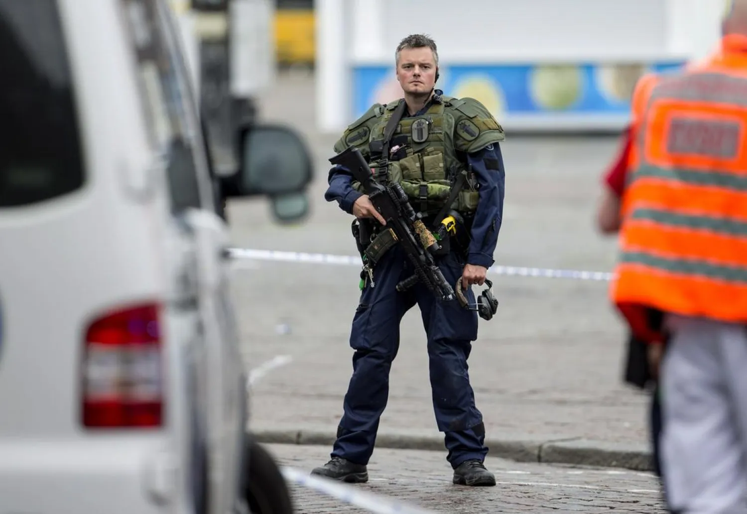 An armed police officer secures the area following a multiple stabbing attack on the Market Square in Turku, Finland. Roni Lehti / Lehtikuva via AP.