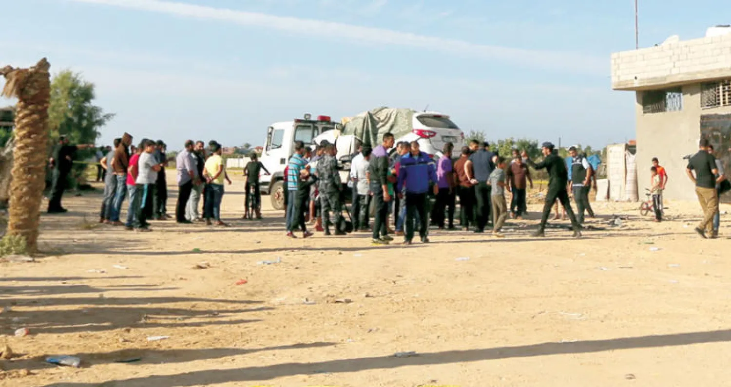 فلسطينيون يتجمعون حول سيارة اللواء توفيق أبو نعيم المسؤول الكبير في حركة {حماس} إثر تعرضها للتفجير في قطاع غزة أمس (أ.ف.ب)