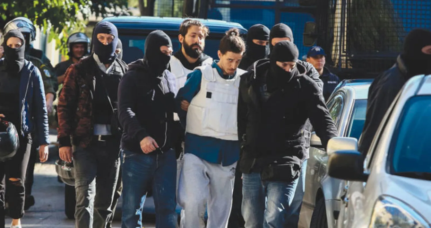 نقل الناشط اليساري الموقوف إلى مكتب النائب العام في أثينا أمس (أ.ف.ب)