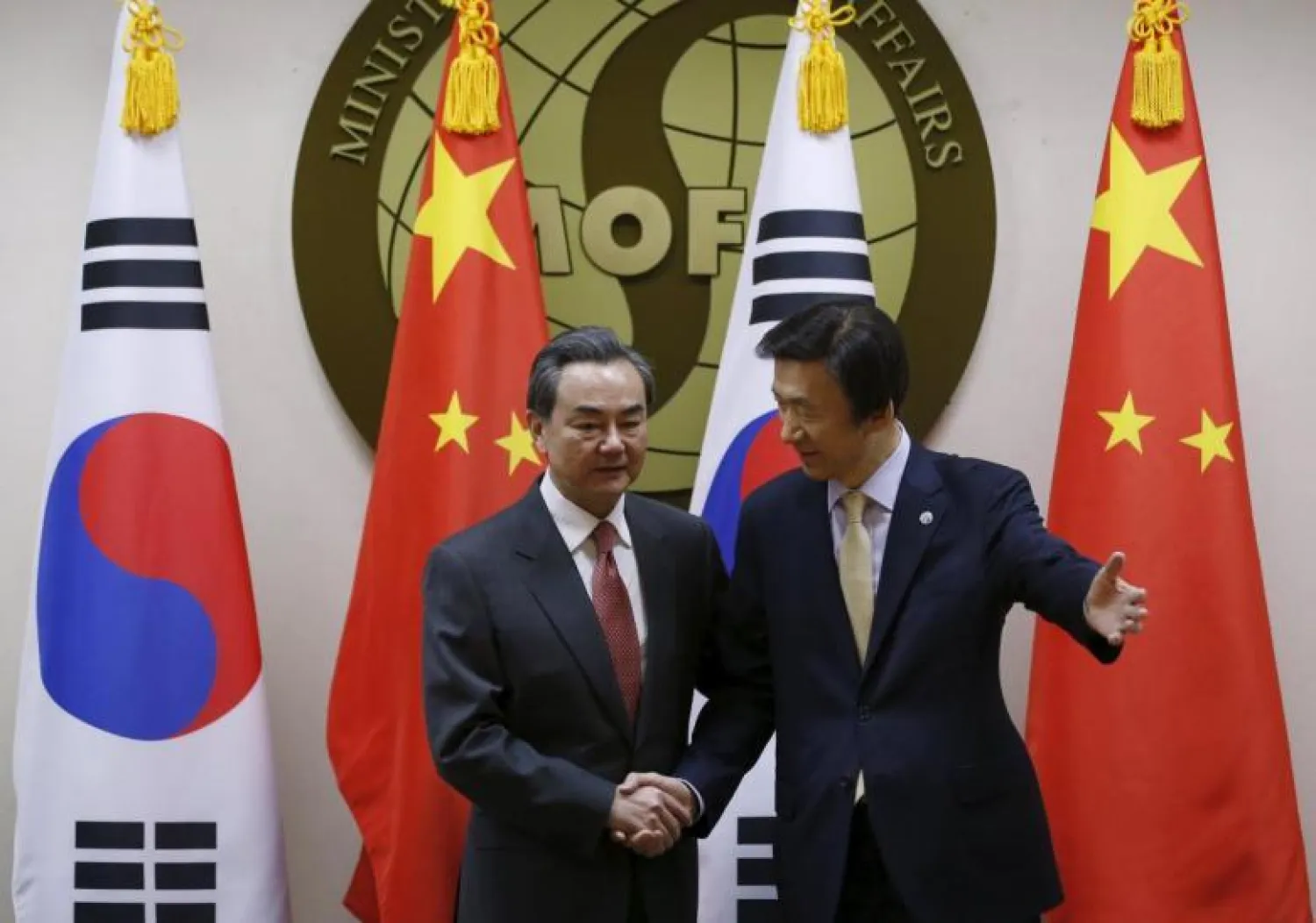 وزير الخارجية الصيني يصافح نظيره الكوري الجنوبي (رويترز)