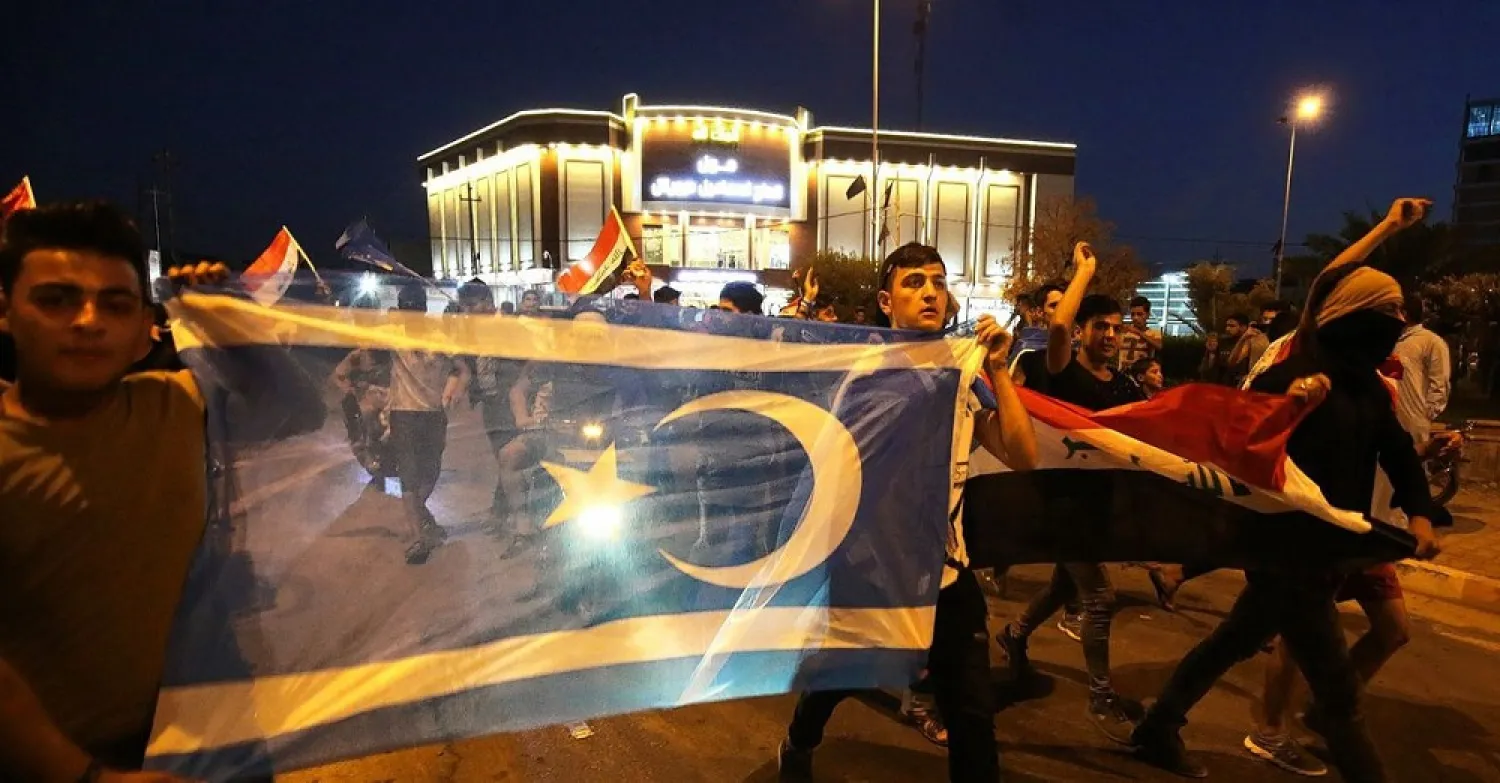 Iraqis hold Iraqi flags and the flag of the Iraqi Turkmen as they gather in the street in the city of Kirkuk to celebrate on October 18, 2017. (AFP)