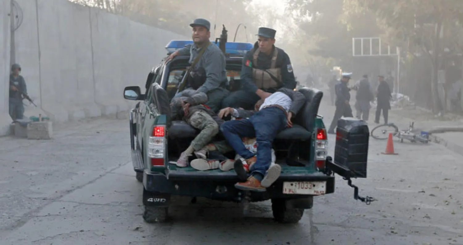 رجال شرطة ينقلون جرحى سقطوا في التفجير الانتحاري الذي ضرب الحي الدبلوماسي في كابل أمس (رويترز)