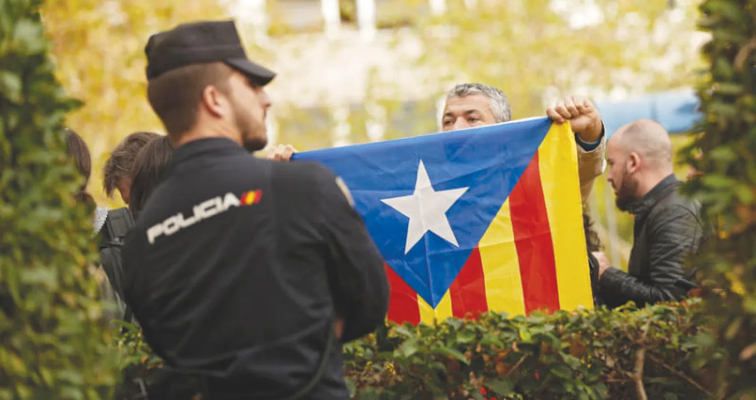 رجل يحمل علم إقليم كاتالونيا (أ.ب)