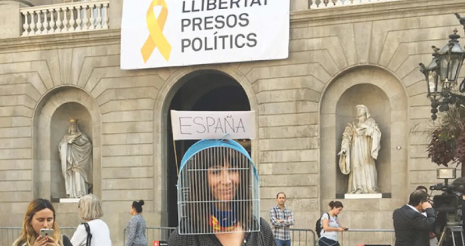 ناشطة كاتالونية تطالب بإطلاق سراح وزراء الإقليم المقالين أمام مقر برلمان كاتالونيا المحلي في برشلونة أمس («الشرق الأوسط»)