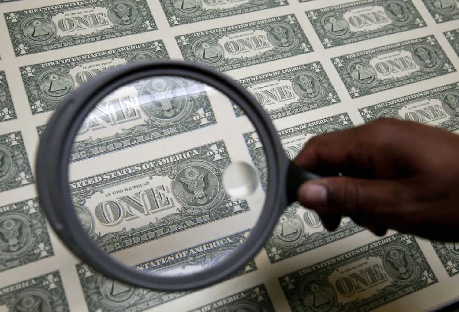 United States one dollar bills are inspected under a magnifying glass during production at the Bureau of Engraving and Printing in Washington November 14, 2014. REUTERS/Gary Cameron