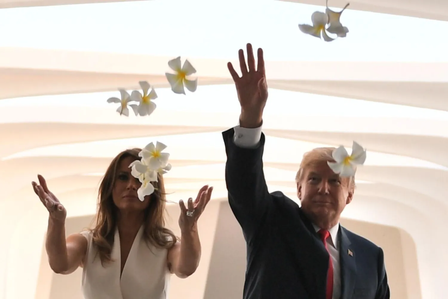 US President Donald Trump and First Lady Melania Trump throw flowers during their visit to the USS Arizona Memorial on November 3, 2017, at Pearl Harbor in Honolulu