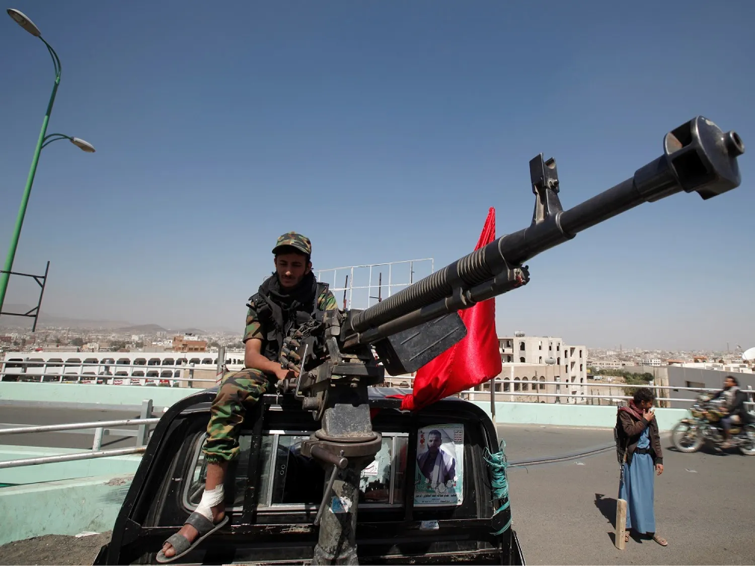 A Houthi militant sits atop a police patrol truck stationed on a bridge in the capital Sana’a. (Reuters)