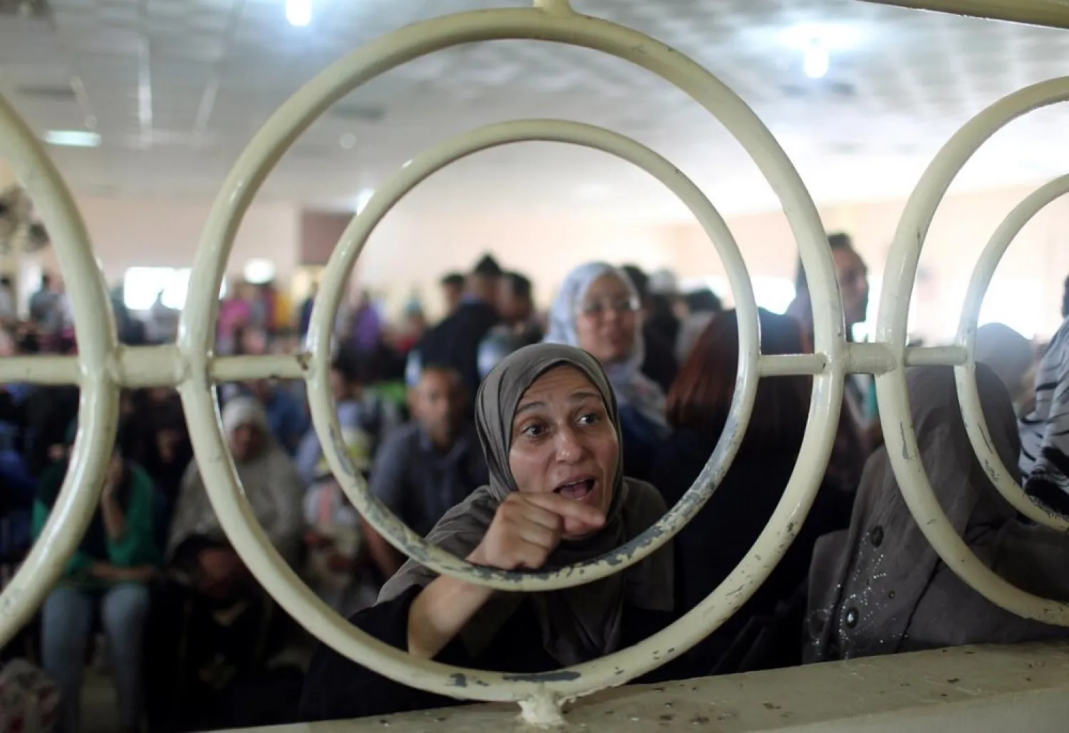 A Palestinian woman gestures as she asks for a travel permit to cross into Egypt through the Rafah border crossing. (Reuters)